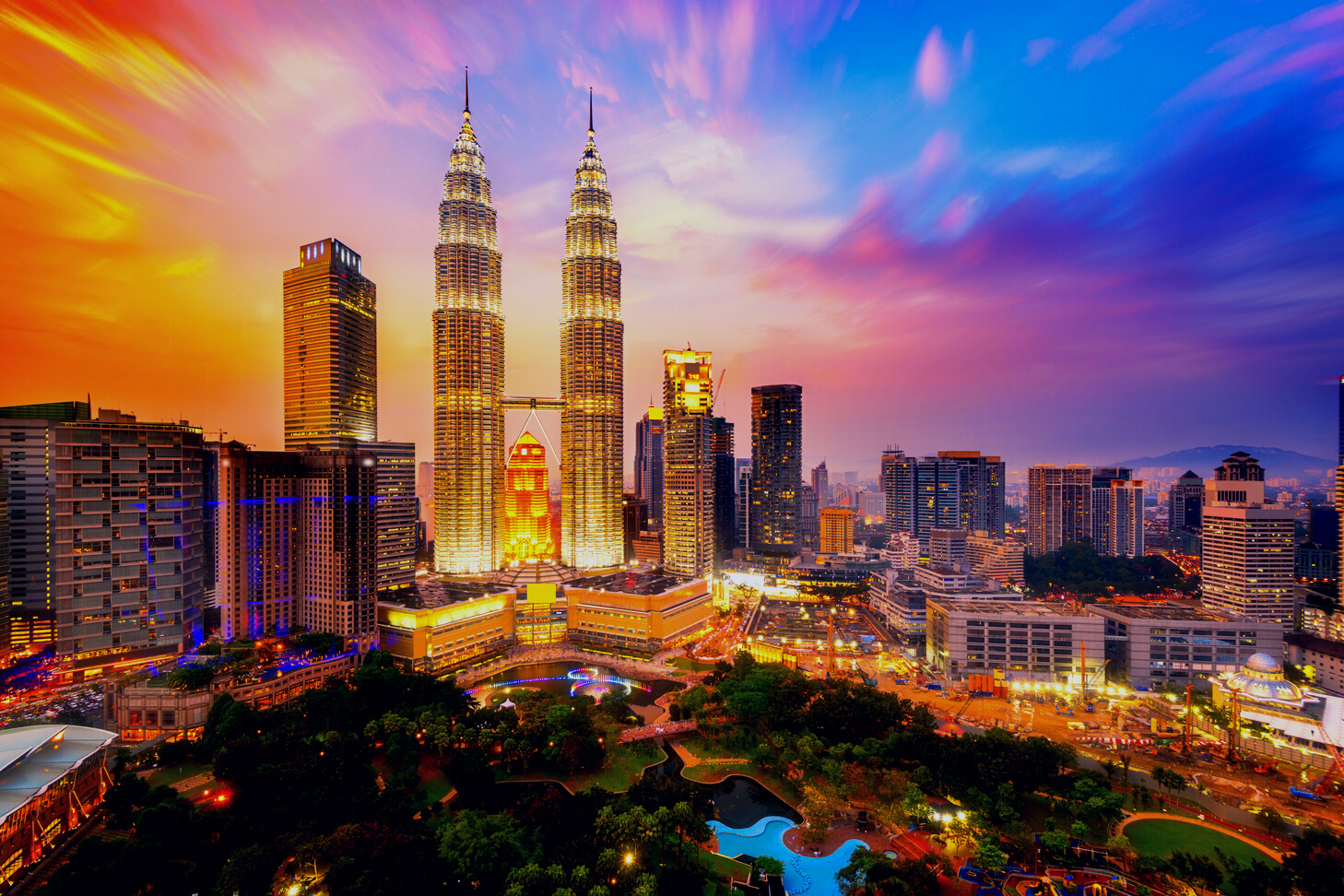 a cityscape with a colorful sky in the background